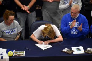 Girl signs scholarship