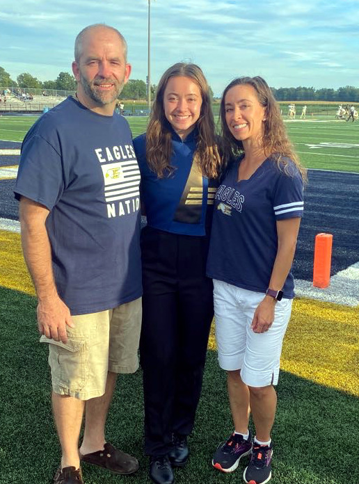 Rebekah and her parents at a football game.